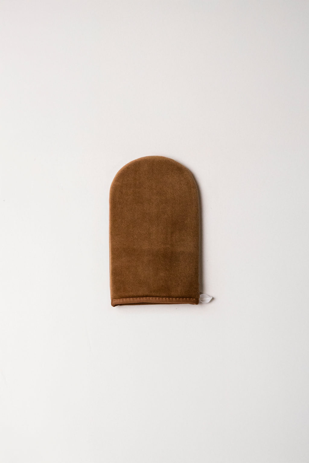 Brown suede tanning mitt on a white background