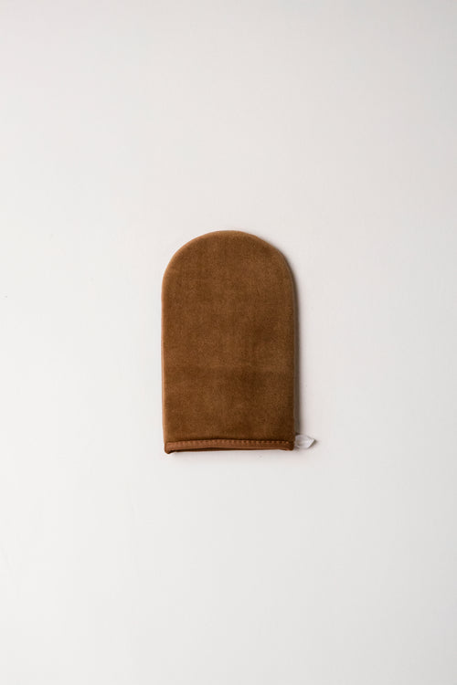 Brown suede tanning mitt on a white background